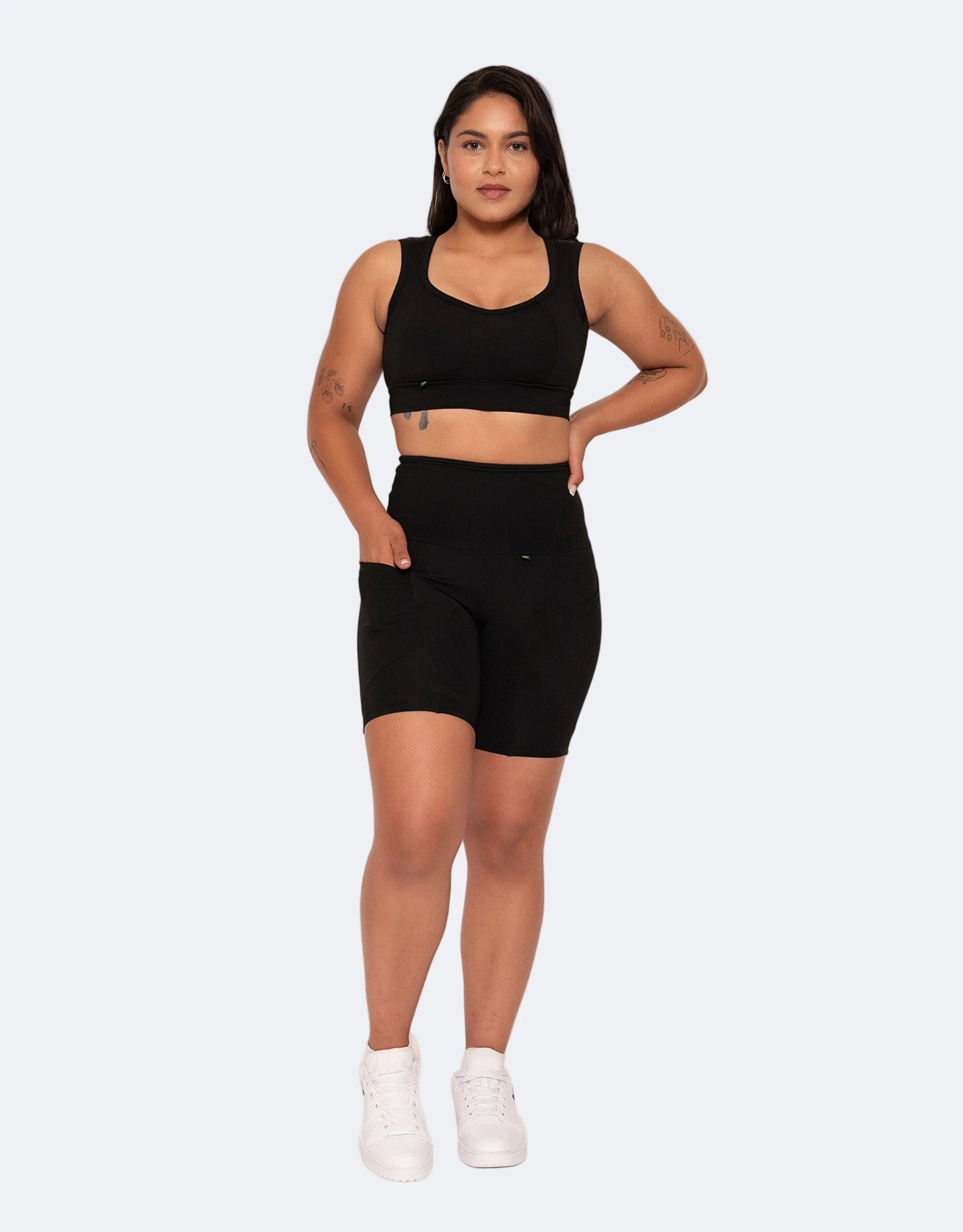 Model wears black high compression shorts with pockets and matching sports bra