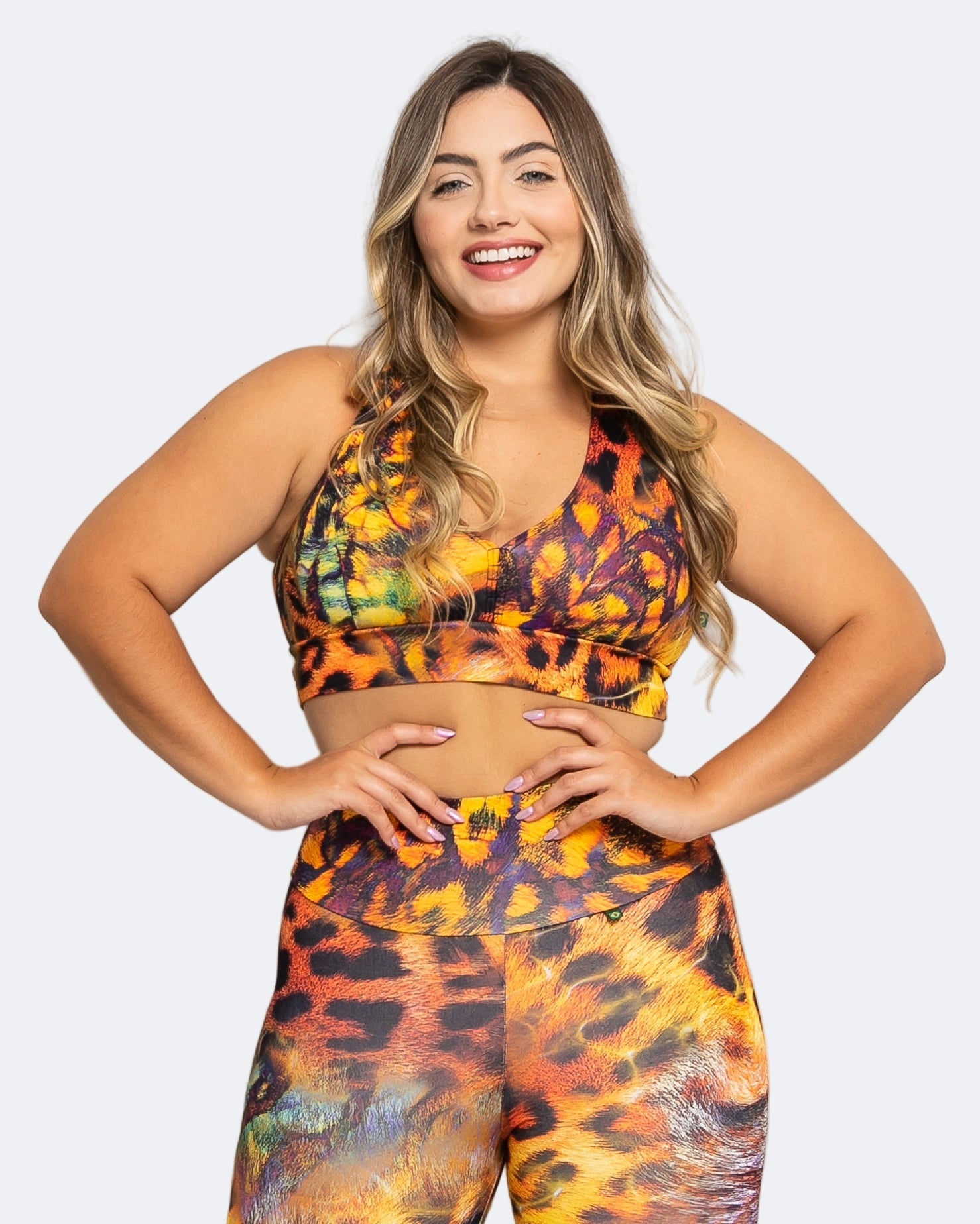 Woman wearing a colorful safari animal print sports bra  on a white background