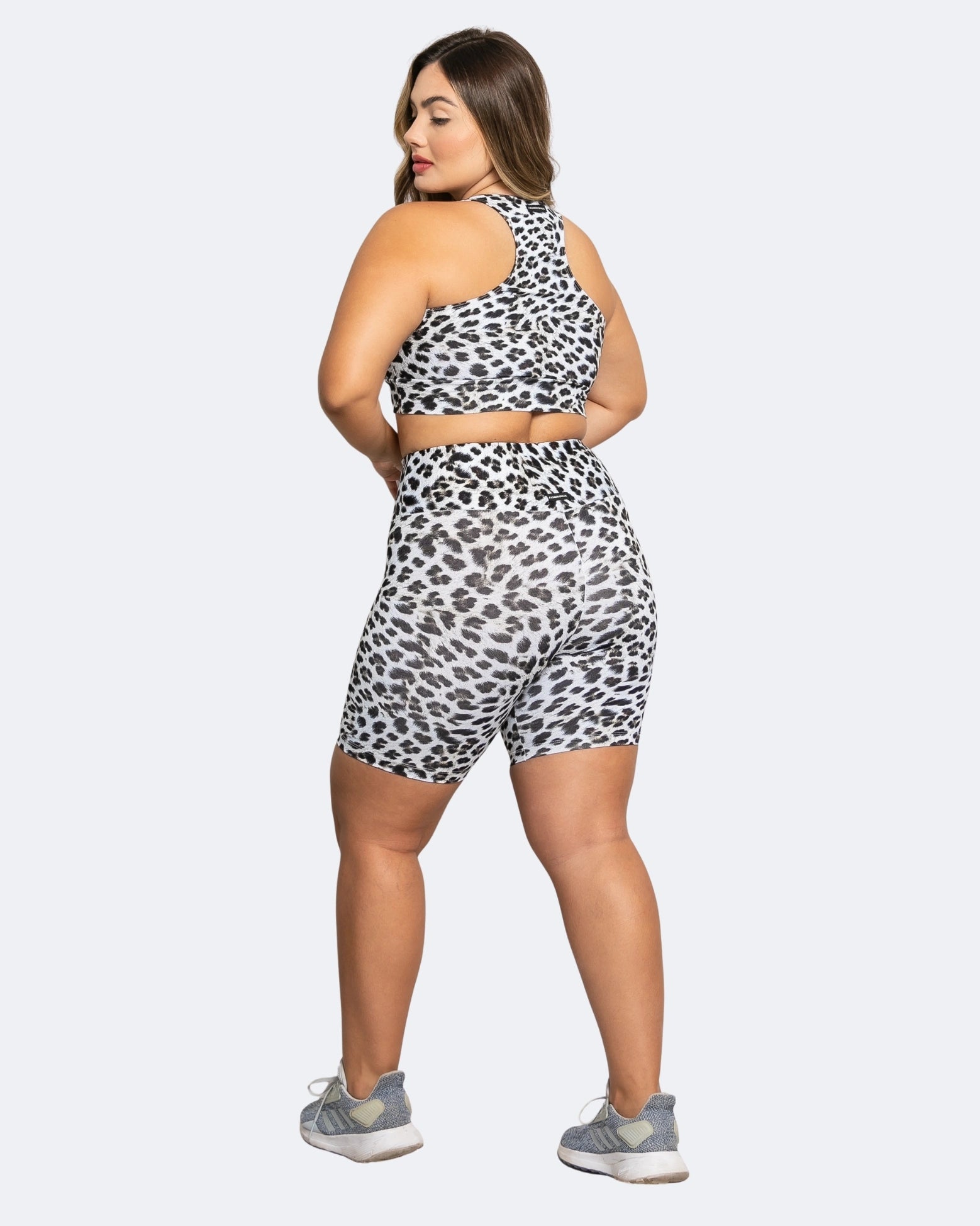 Woman wearing a leopard print outfit on a white background