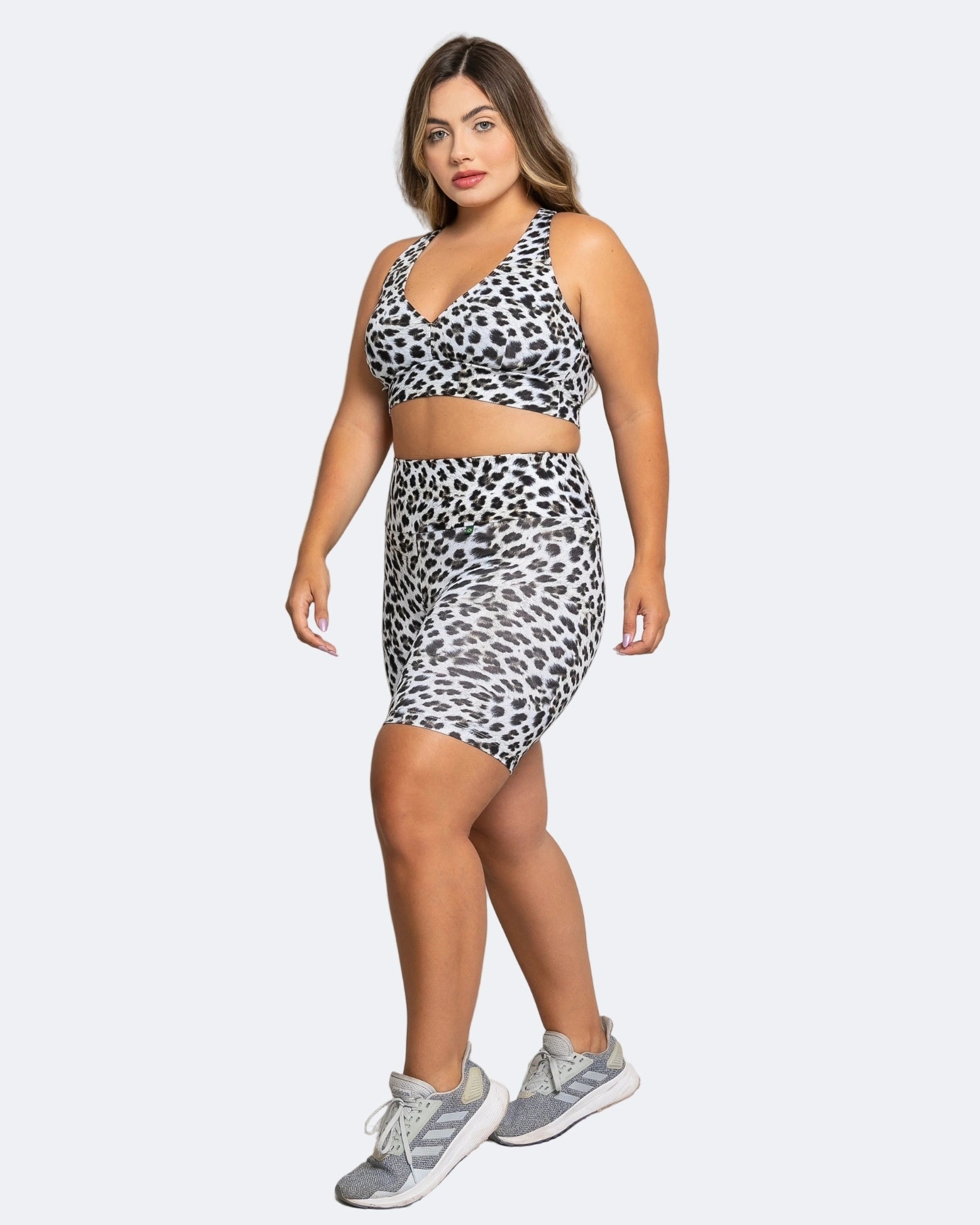 Woman wearing a leopard print two-piece outfit on a white background