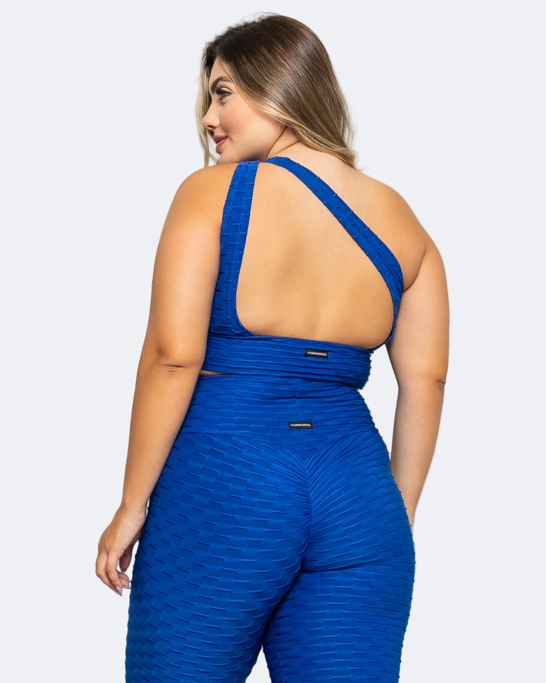 Woman wearing a blue jumpsuit with a white background