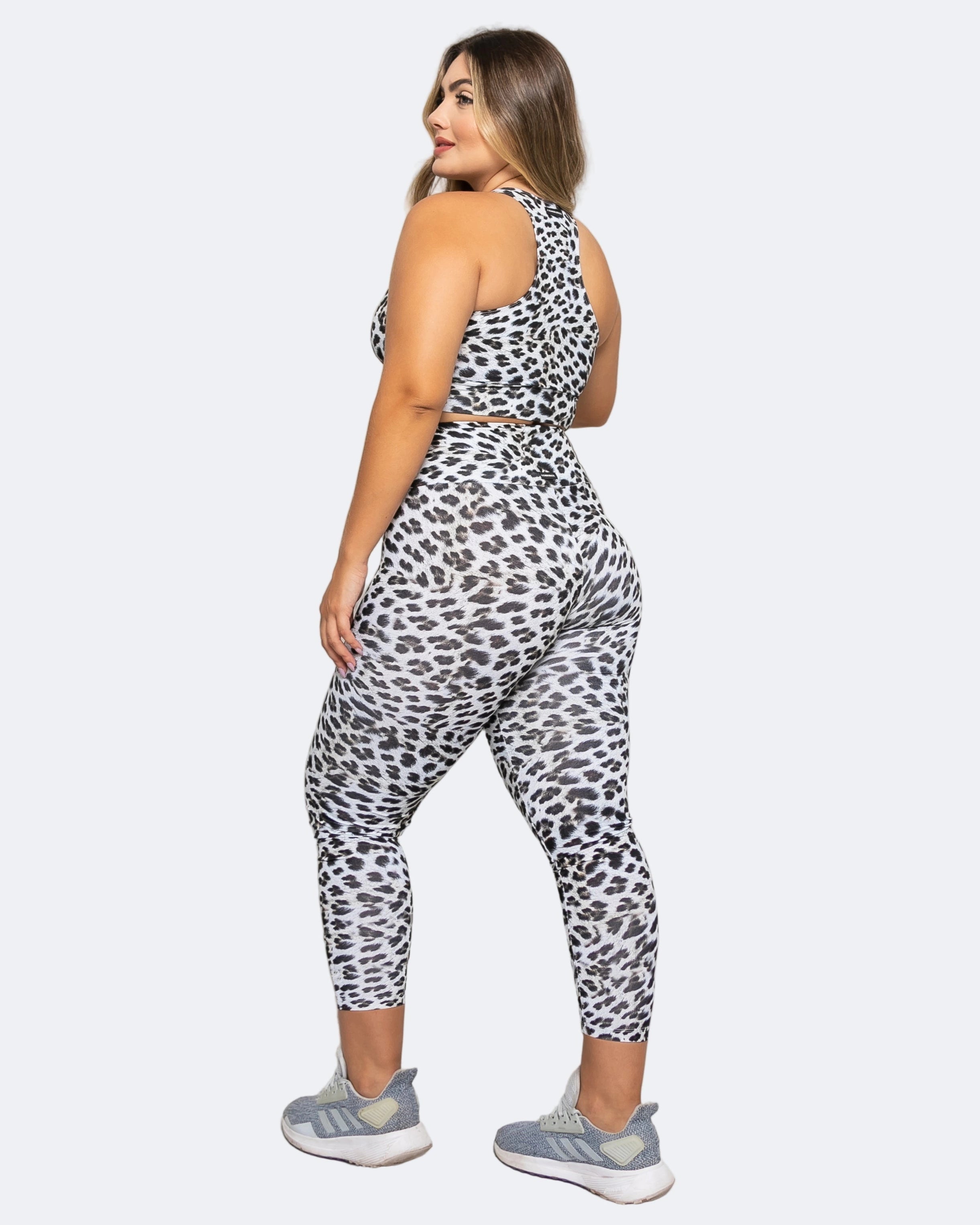 Woman wearing a leopard print jumpsuit on a white background