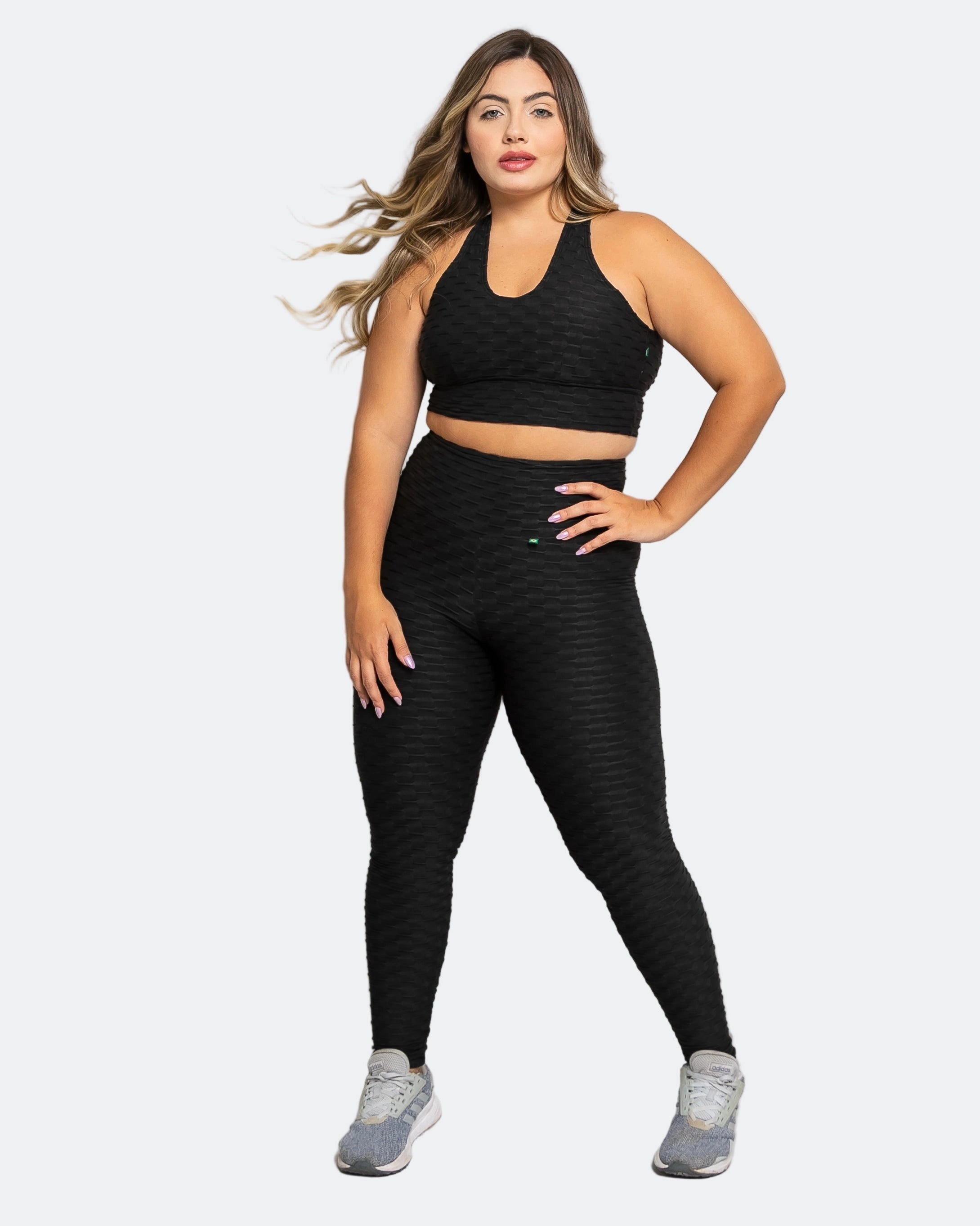 Woman wearing a black athletic outfit on a white background
