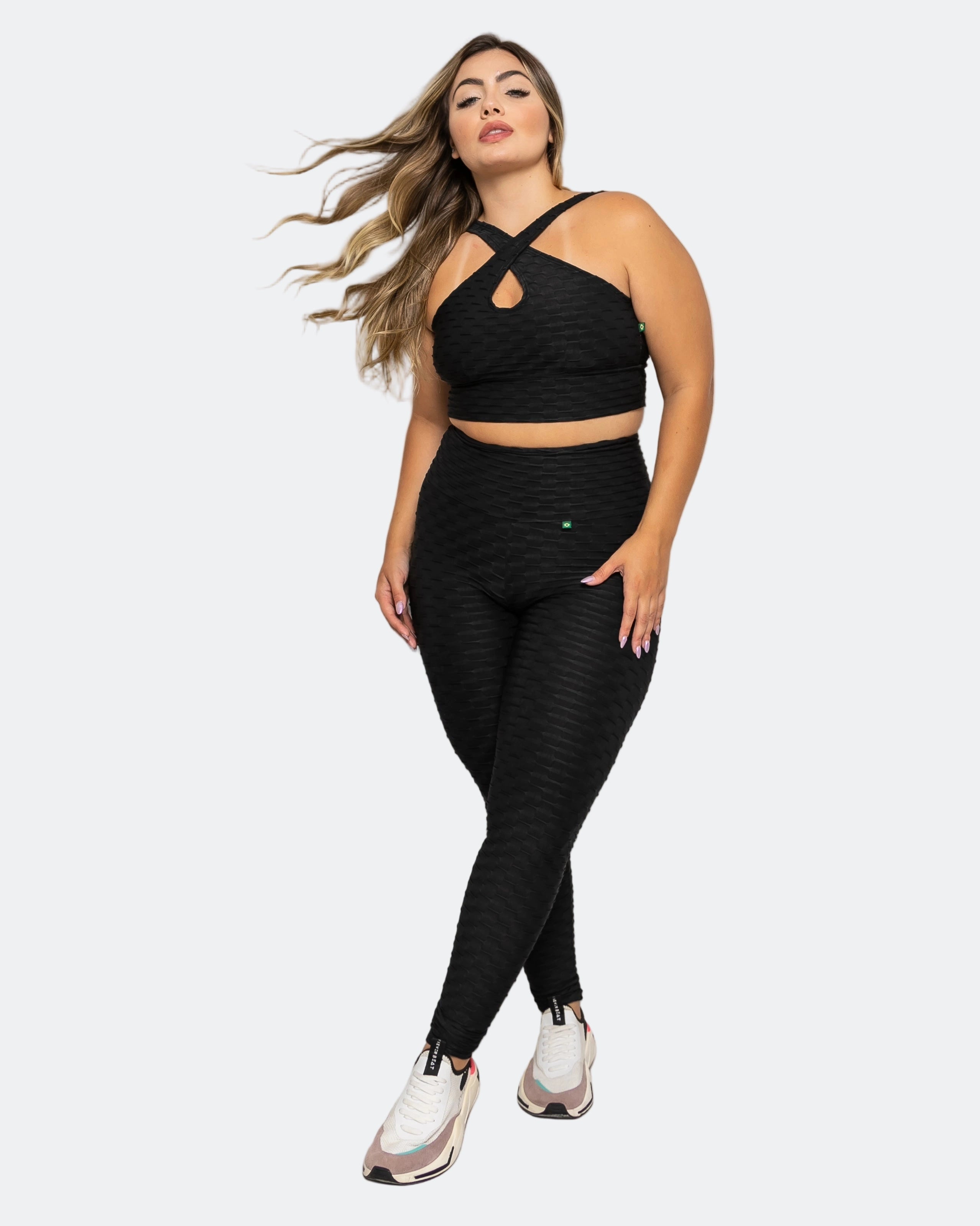 Woman wearing a black athletic outfit on a white background