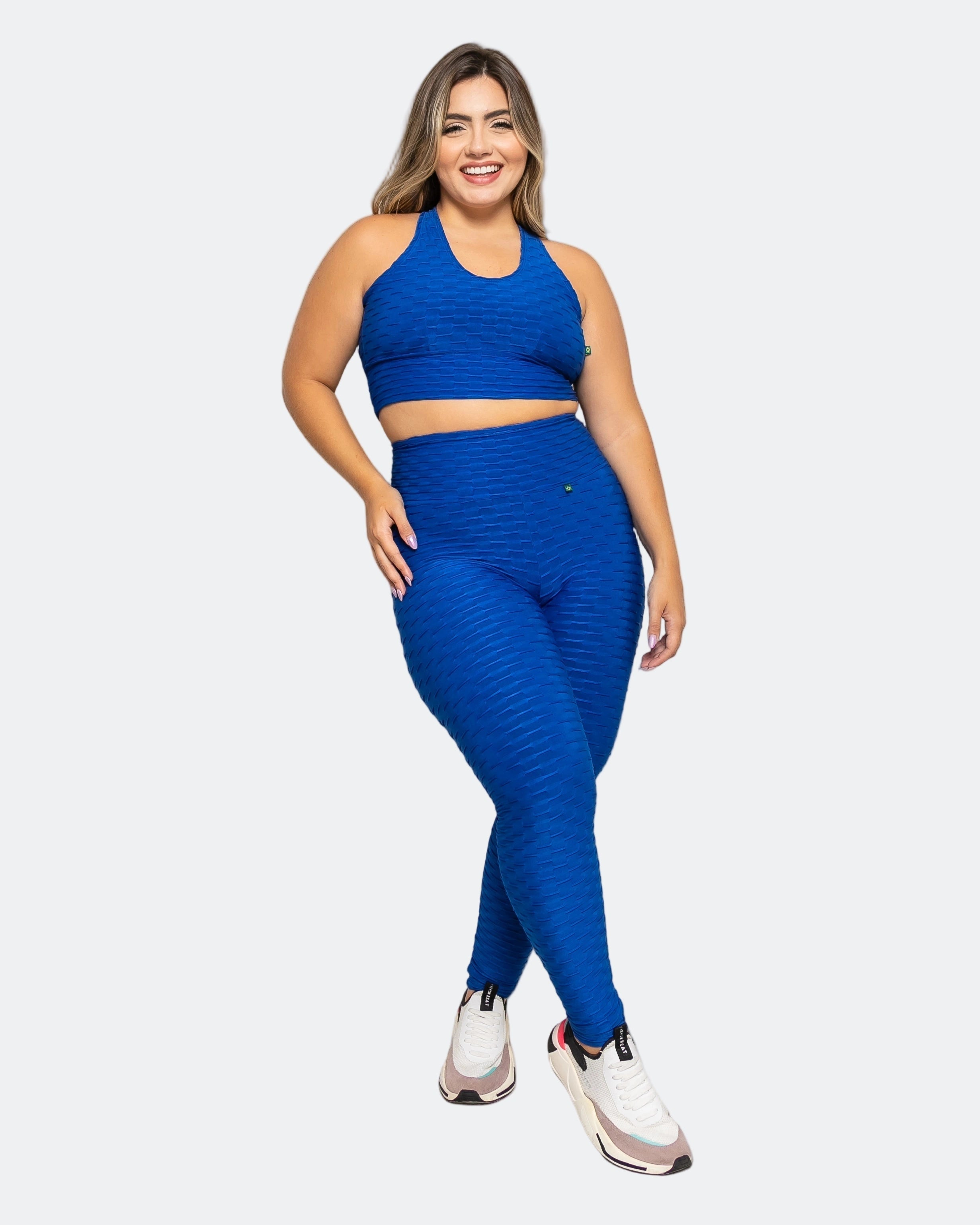 Model wearing Fashion Brazil blue high-waisted scrunch booty legging and a matching sports bra, standing against a plain background. 