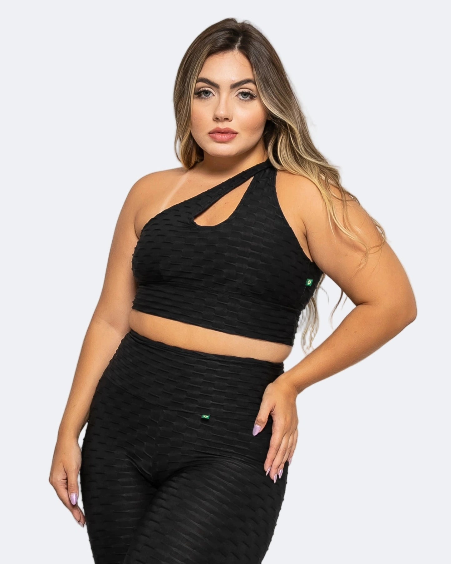 Woman wearing a black sports bra and leggings set on a white background