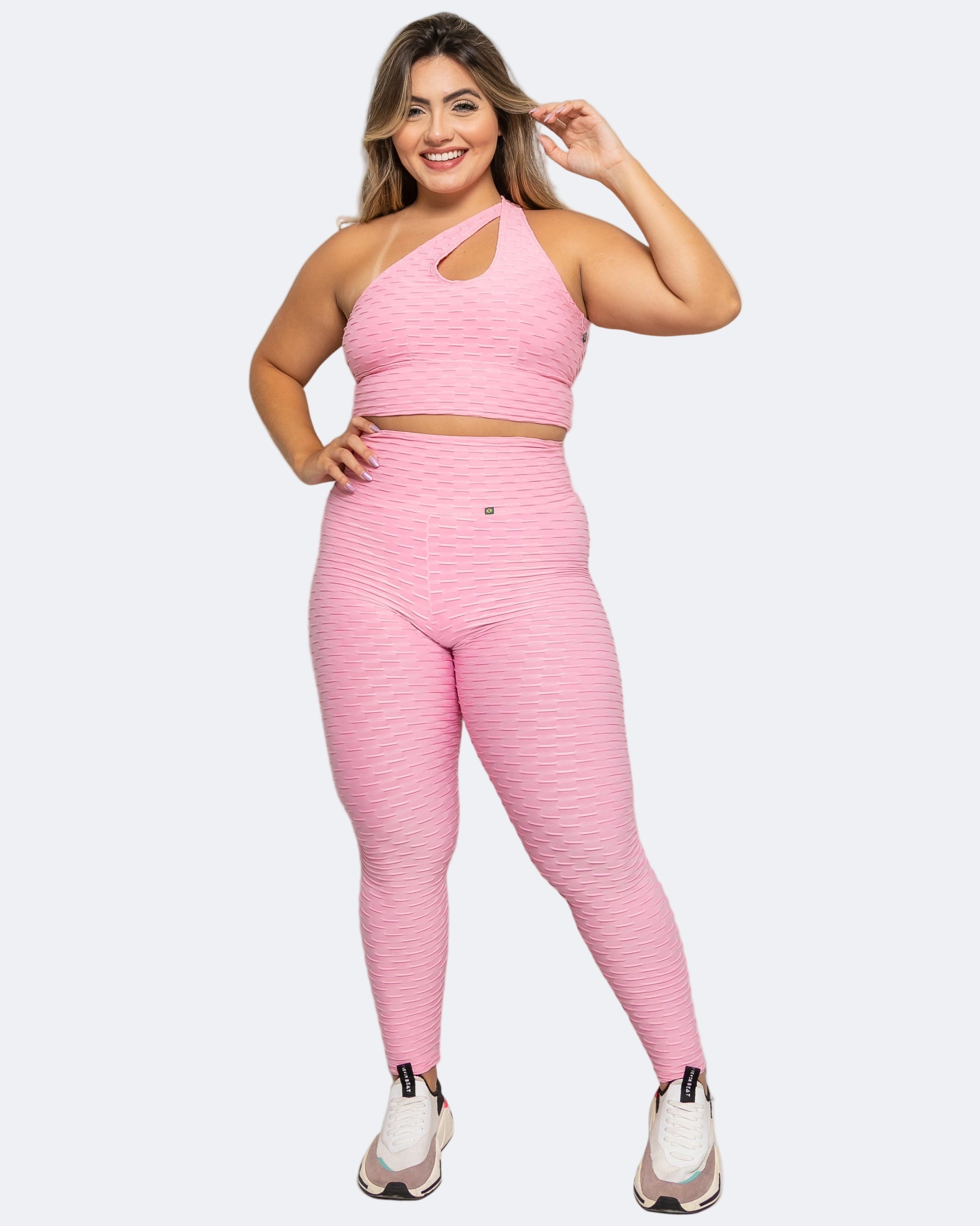 Woman wearing a pink athletic outfit on a white background