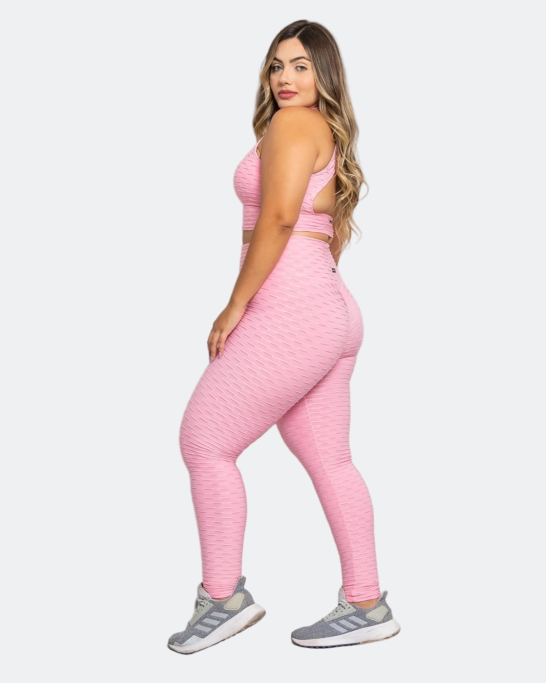 Woman wearing a pink athletic outfit on a white background