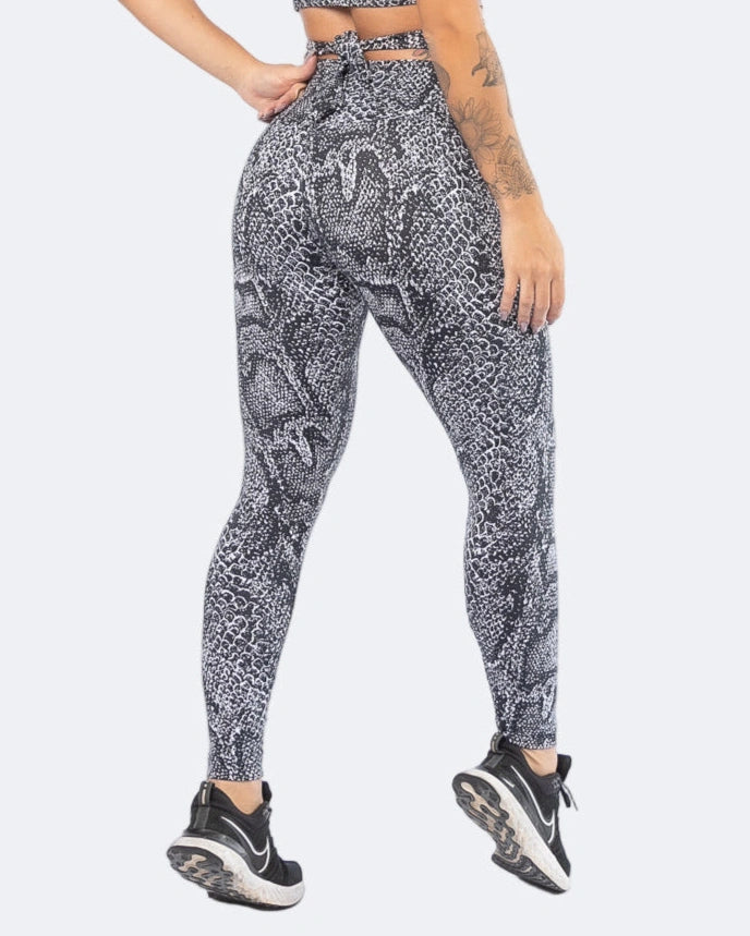 Person wearing black and white patterned leggings on a white background