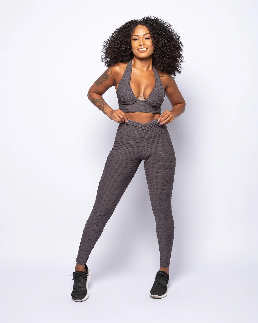 Woman wearing a gray athletic outfit on a white background