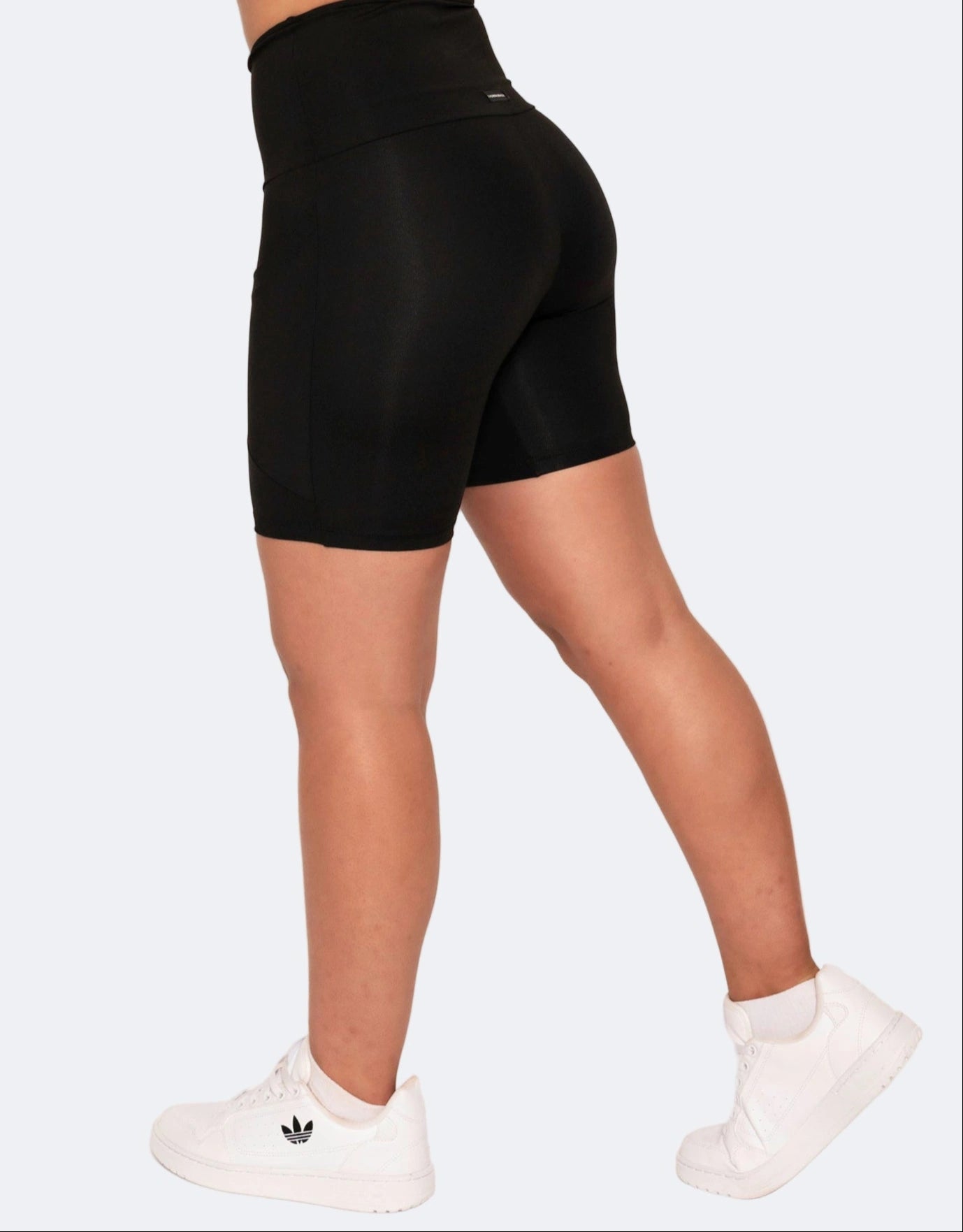 size view of  mid length black high waisted shorts with side pockets. 