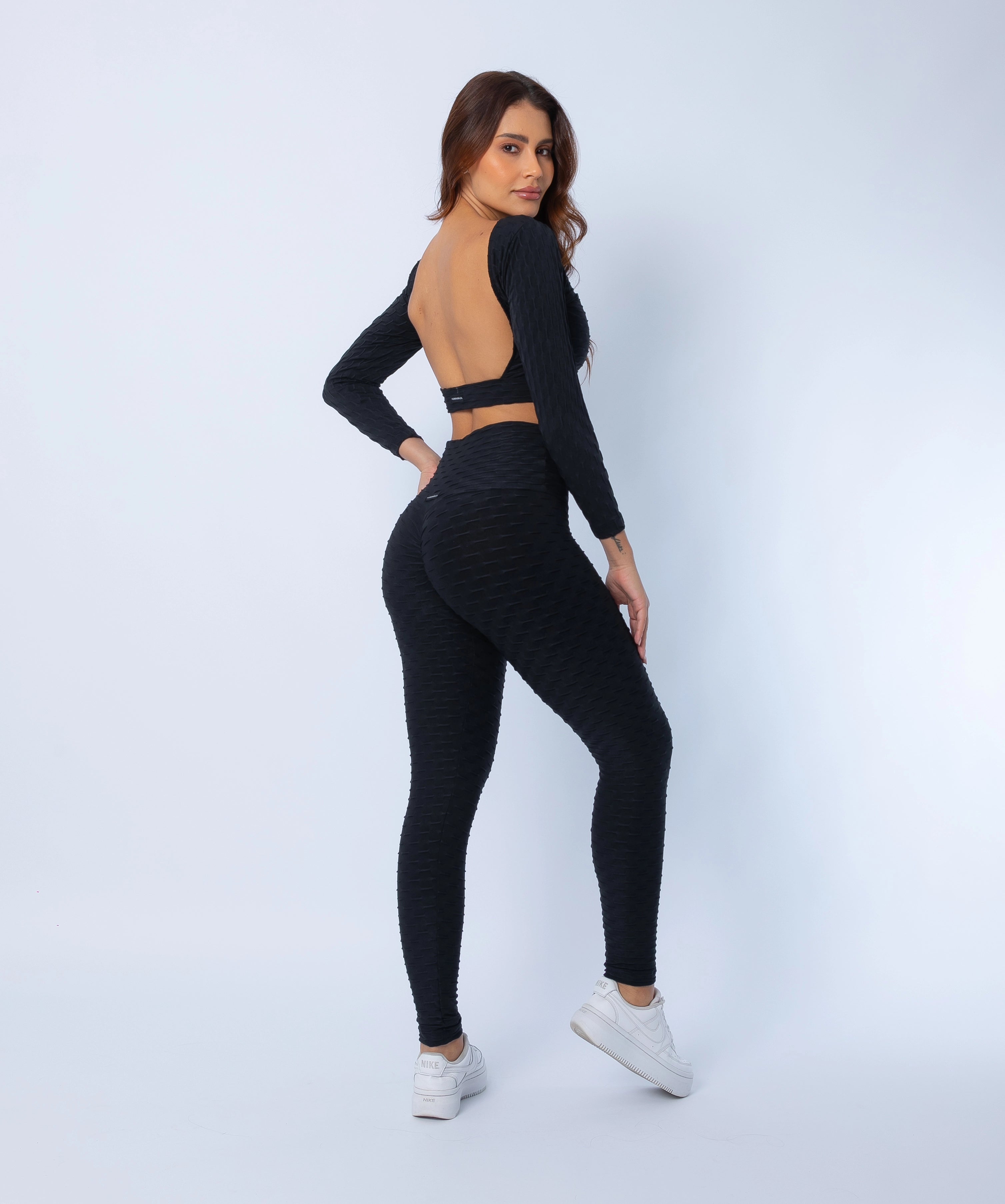 Fashion Brazil Luna Zero Flaws Scrunch Booty Leggings and Long Sleeve Crop Top set, back-side view showing sculpting scrunch-back leggings and open-back crop top in black zero flaws textured fabric.