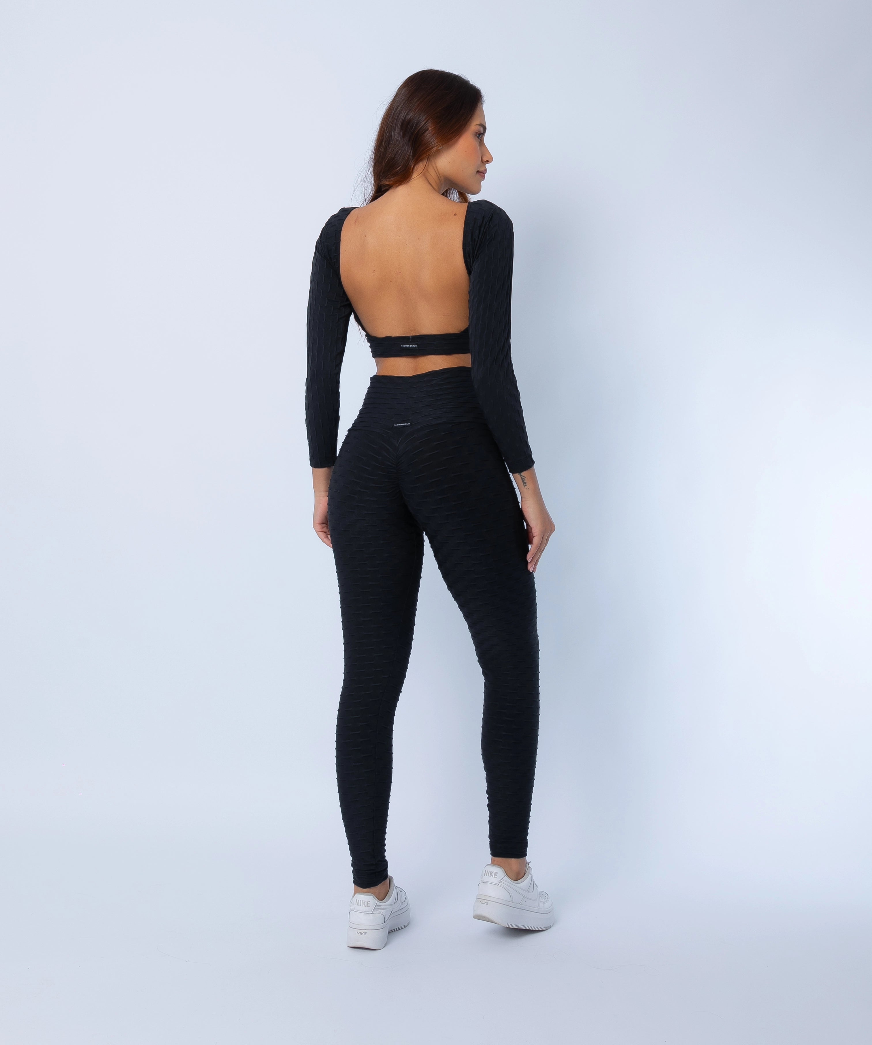 Fashion Brazil Luna Zero Flaws Scrunch Booty Leggings and Long Sleeve Crop Top set, back-side view showing sculpting scrunch-back leggings and open-back crop top in black zero flaws textured fabric.