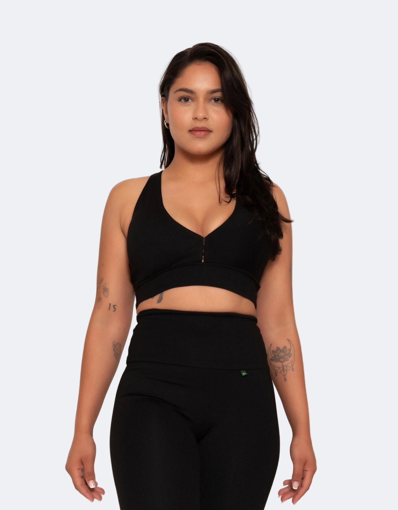 Model wears black sports bra on a white background