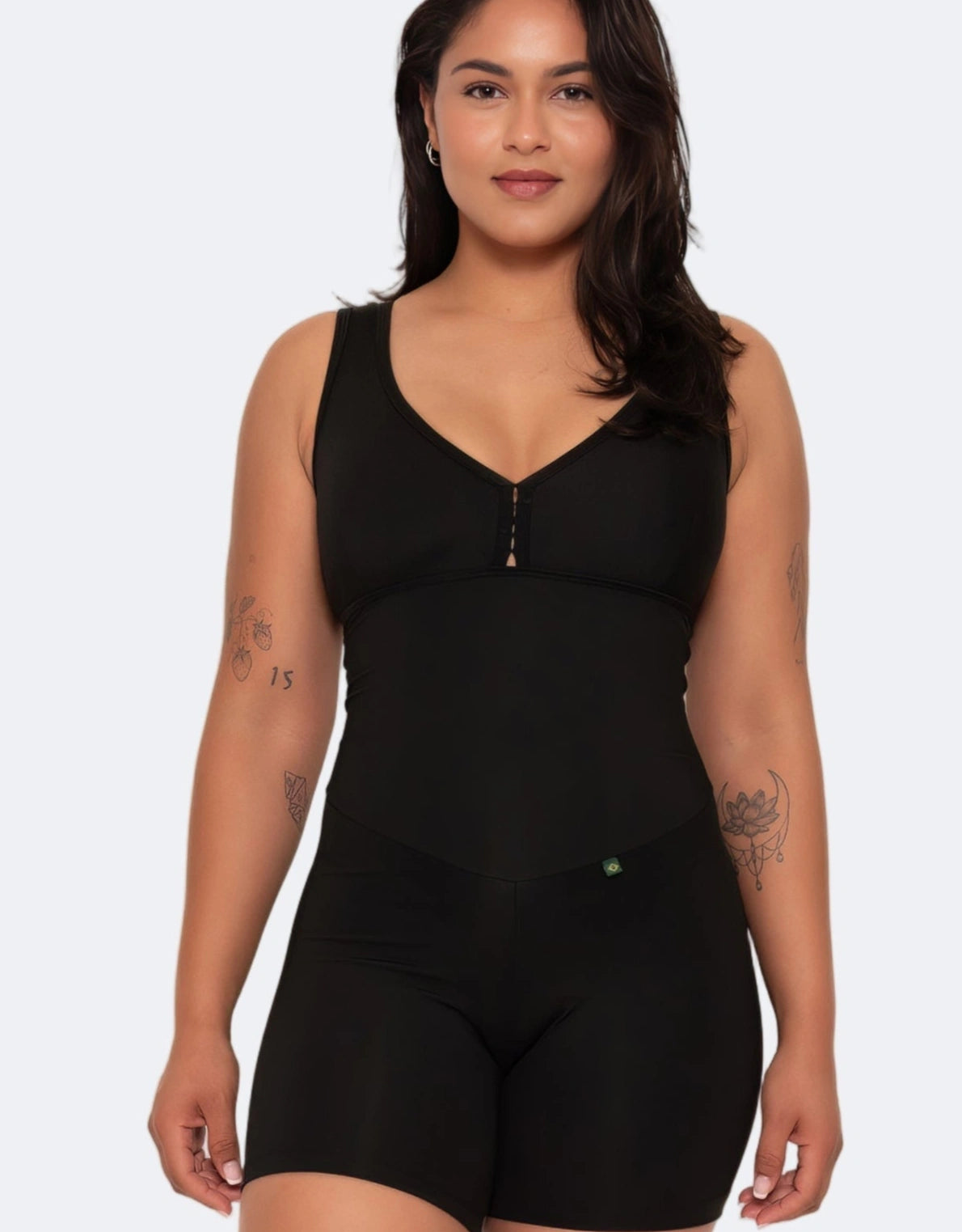 Woman wearing a black bodysuit against a white background