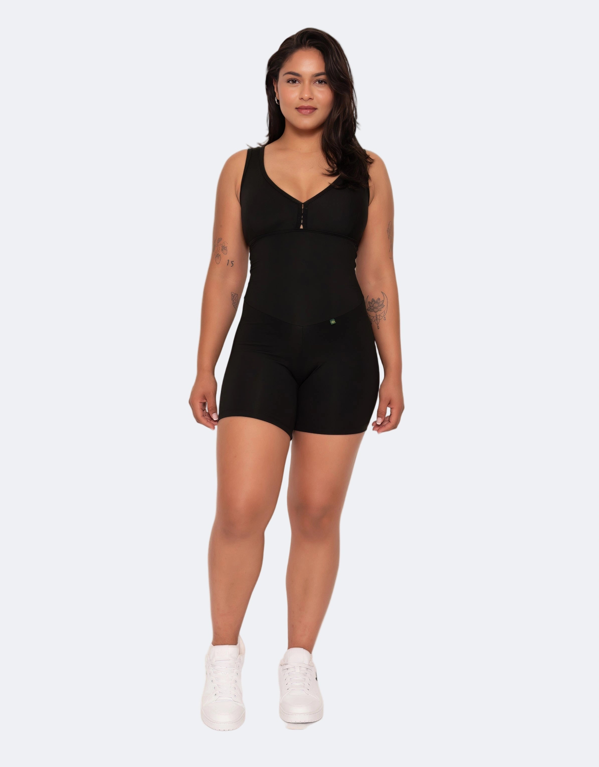 Woman wearing a black sleeveless jumpsuit on a white background